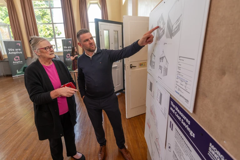 A representative from Lovell shows a drawing of some plans to a customer