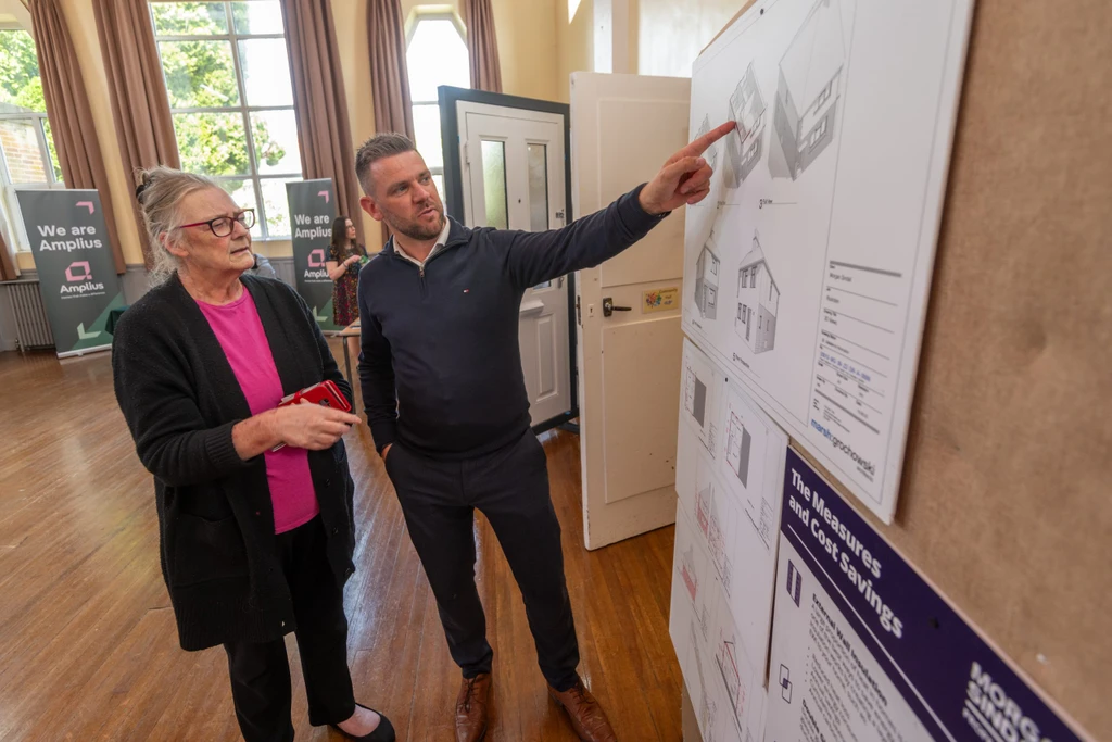 A representative from Lovell shows a drawing of some plans to a customer