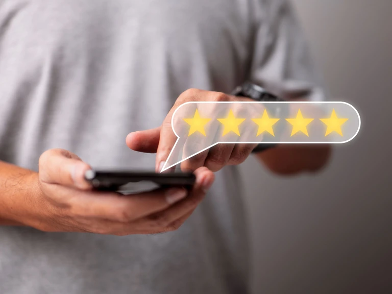 Man holding a mobile phone and rating a service with five stars