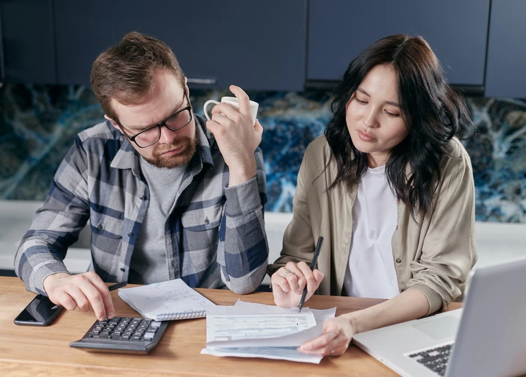 Customers looking at rent letters with a notepad and calculator