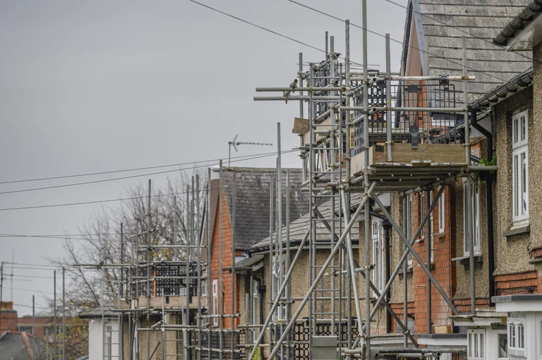Row of older houses with scaffolding built up around them