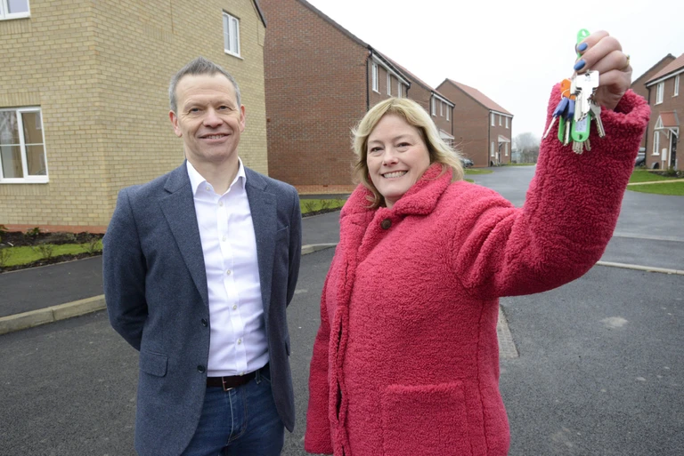 Representatives from Amplius and Allison Homes stood outside a home