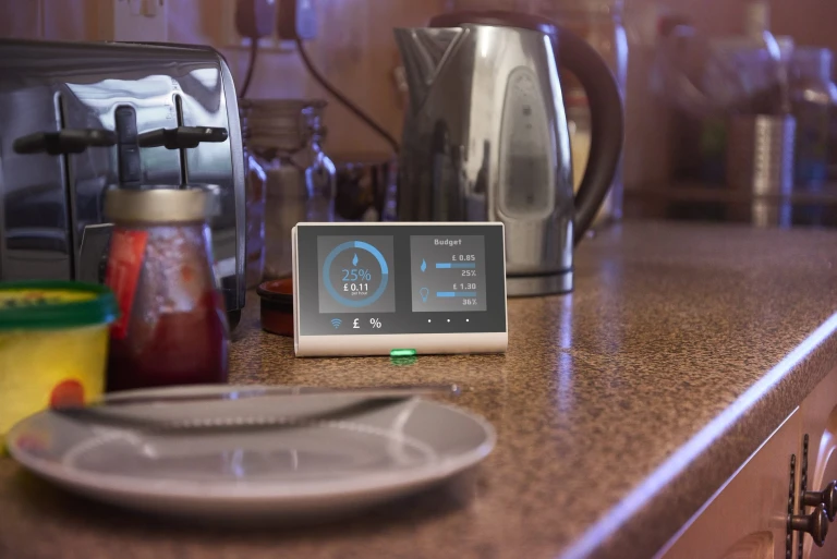 An energy smart meter on the kitchen work surface with a kettle beside it