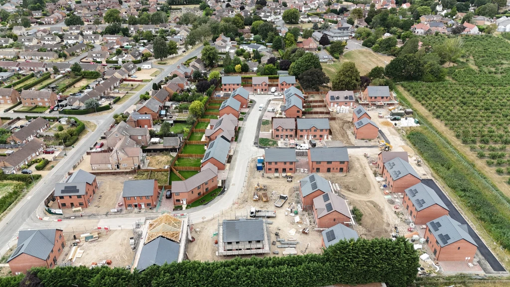 An aerial view of a building site with houses at various stages of completion.