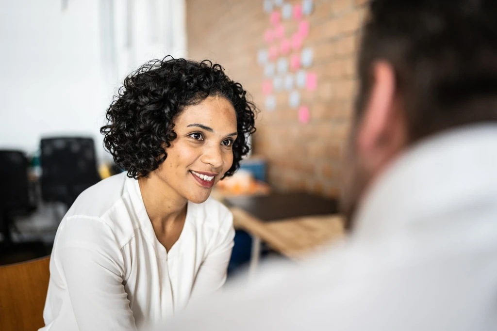 Woman with dark hair talking to a man